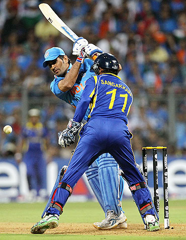 Mahendra Singh Dhoni plays the ball fine as Kumar Sangakkara looks on