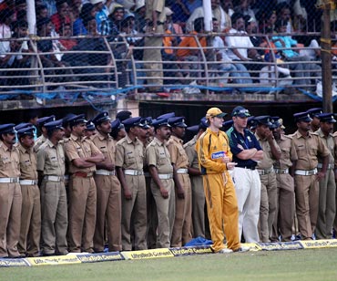 Michael Clarke with the Australian team security officer on from the boundary as a large number of police surround the field in Kochi