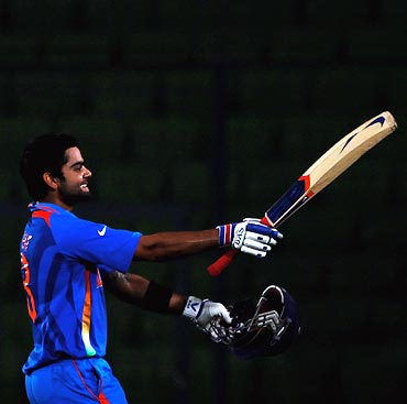 Virat Kohli raises his bat on reaching his century
