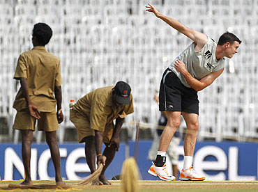 New Zealand's James Franklin (right) bowls as ground workers clean the pitch during a practice session in Chennai on Friday