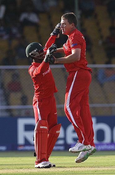 Zimbabwe's Ray Price (right) celebrates with teammate Tatenda Taibu after dismissing David Hussey