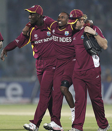 West Indies' Dwayne Bravo (centre) is helped off the field after being injured