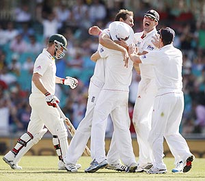 English players congratulate Chris Tremlett (centre) for taking the wicket of Australia's Brad Haddin (left) on Thursday