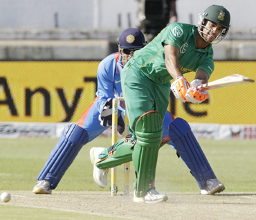 South Africa's JP Duminy plays a shot with MS Dhoni looking on during the one day international cricket match against India at Kingsmead Stadium in Durban
