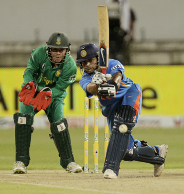 India's Virat Kholi (R) plays a shot as South Africa's wicketkeeper AB De Villiers looks on during the day international cricket match against South Africa at Kingsmead Stadium in Durban