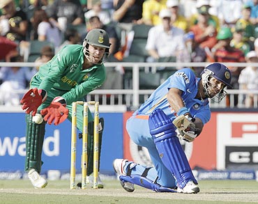 India's Yuvraj Singh plays a shot as AB De Villiers looks on
