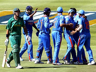 India's Murali Vijay (2nd left), MS Dhoni (3rd left), Yuvraj Singh (4th left), Suresh Raina (3rd right),  Harbhajan Singh (2nd right) and Virat Kohli (R) celebrate the wicket of South Africa's Graeme Smith (L) during their third one-day international cricket match in Cape Town
