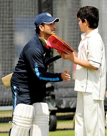 Sachin Tendulkar and his son share a moment during India's practice session