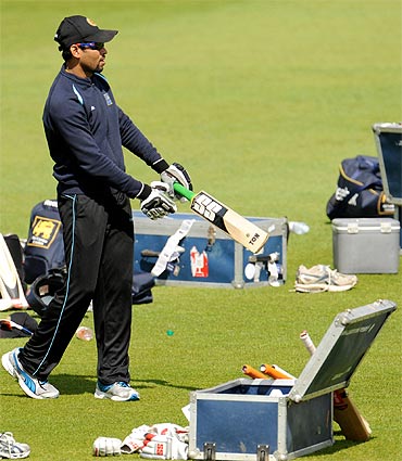 Sri Lanka's injured captain Tillakaratne Dilshan (R) holds a bat next to Duleep Mendis during a training session before Thursday's third cricket test match against England at the Rose Bowl