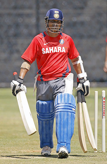 Sachin Tendulkar carries his bats to the nets during a practice session in Bangalore on Saturday