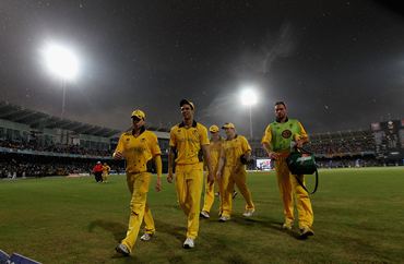 Australia's players walk off the field as rain lashes the ground