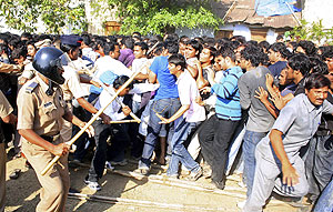Police officers wielding sticks try to control a crowd of fans outside the Vidarbha Cricket Association Stadium in Nagpur on Tuesday