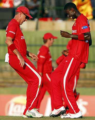 Zimbabwe's Ray Price (L) and Chris Mpofu celebrate after dismissing Sri Lanka's Upul Tharanga