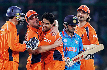 Dutch player Mudassar Bukhari (centre) celebrates with captain Peter Borren after dismissing India's Gautam Gambhir