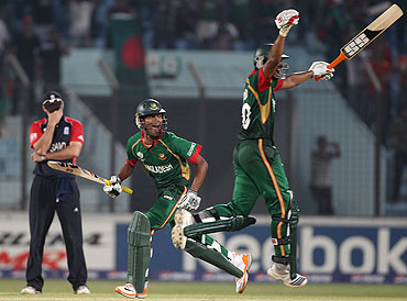 Shafiful Islam and Mahmudullah of Bangladesh celebrate scoring the winning runs as Andrew Strauss of England holds his head in his hands