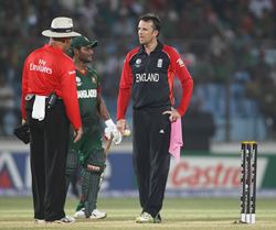 Graeme Swann has words with umpire Daryl Harper about the wet ball