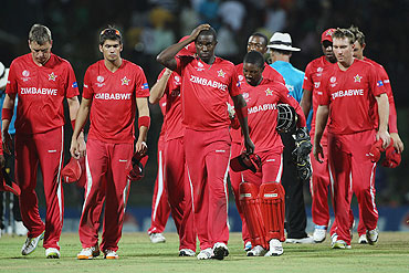 Zimbabwe captain Elton Chigumbura (3rd from left) leads his dejected players off after their seven wicket defeat against Pakistan on Monday