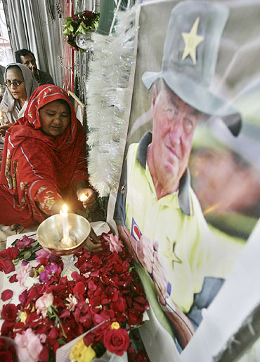 A Pakistani Christian peace activist places a rose in front of a picture of cricket coach Bob Woolmer during a memorial service in Islamabad in 2007
