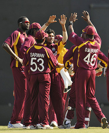 West Indies' Devendra Bishoo (centre) is congratulated by his teammates after claiming the wicket of England's Jonathan Trott on Thursday
