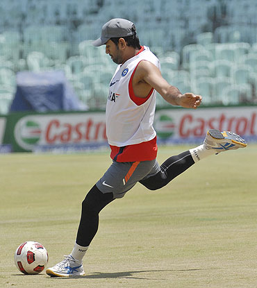 India's captain Mahendra Singh Dhoni plays football during a practice session on Friday