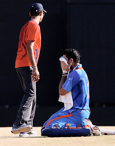 Yuvraj Singh (centre) is attended to by Team India's physio Dr Nitin Patel