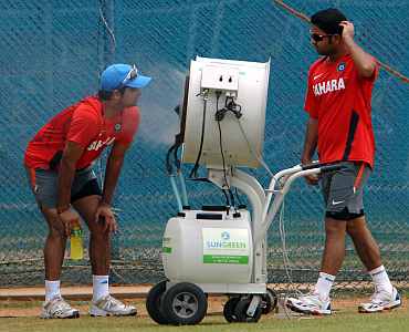 Suresh Raina stands in front of a misting fan as teammate Chawla looks on