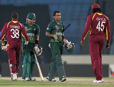 Pakistan's Mohammad Hafeez and Kamran Akmal shake hands with West Indies players after winning their match