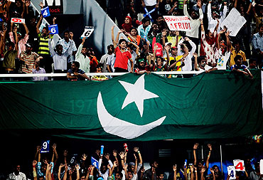 Fans celebrate as a Pakistan flag is draped over a balcony in Dhaka during Pakistan's quarter-final against West Indies