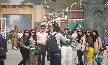 Pakistani cricket fans pose for a photographer before crossing the Wagah border on Tueday