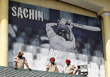 Policemen keep watch in front of a poster featuring India's Sachin Tendulkar in Mohali on Tuesday