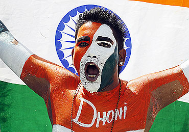 An Indian cricket fan cheers at the start of the match