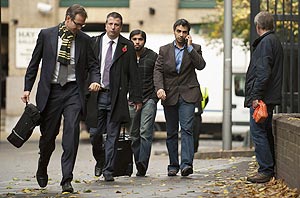 Salman Butt (second right) speaks on the phone as he arrives at Southwark Crown court on Thursday