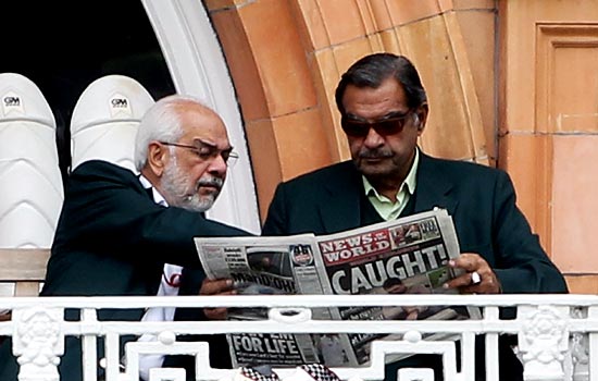 Yawar Saeed (right) reads the News of the World newspaper