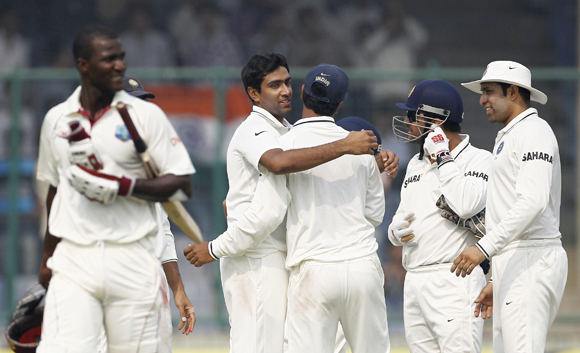 India's Ravichandran Ashwin (2nd L) celebrates with his team mates after dismissing West Indies' captain Darren Sammy (L) during the third day of their first test cricket match in New Delhi