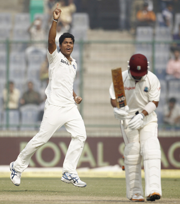 India's Umesh Yadav celebrates after dismissing West Indies Carlton Baugh (R) during the third day of their first test cricket match in New Delhi