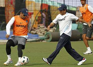 Ms Dhoni and Sachin Tendulkar play football during a practice session