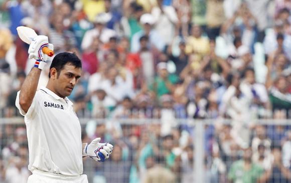 India's captain Mahendra Singh Dhoni raises his bat to celebrate his century