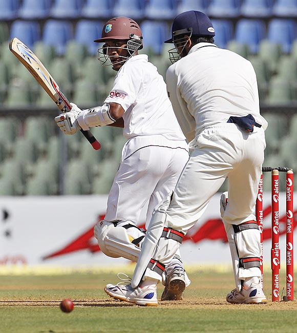 Kraigg Brathwaite plays a shot past India captain and wicket keeper Mahendra Singh Dhoni