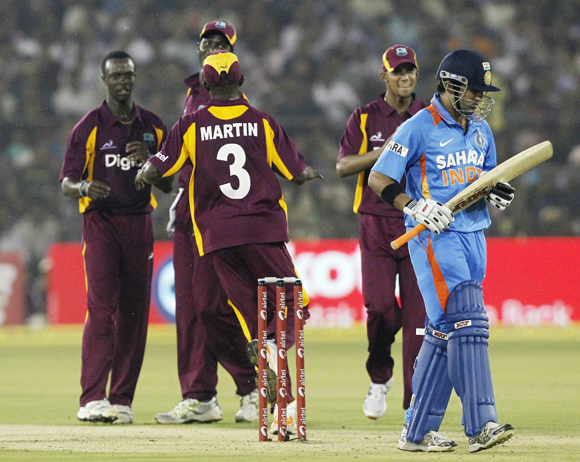 West Indies' Kemar Roach (L) celebrates with teammates after dismissing India's Gautam Gambhir (R) during their first one-day international cricket match in Cuttack