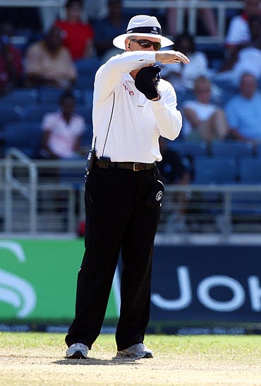 Umpire Tony Hill signals for a referral