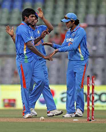 Varun Aaron celebrates after picking up a wicket