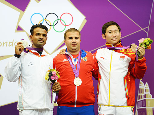 Gold medallist Leuris Pupo (centre) of Cuba, silver medallist Vijay Kumar of India and bronze medallist Feng Ding of China pose on the podium