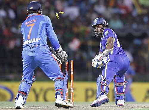 Sri Lanka's Lahiru Thirimanne (R) is bowled out by India's Ravichandran Ashwin during the Twenty20 match