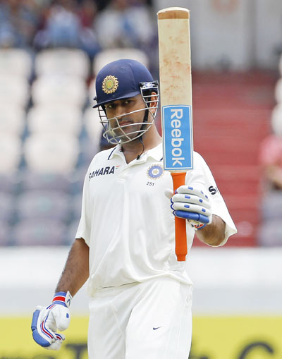 India's captain Mahendra Singh Dhoni raises his bat to celebrate scoring 50 runs