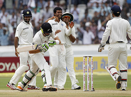 India's Pragyan Ojha (centre) celebrates with teammates after taking the wicket of New Zealand's Martin Guptill