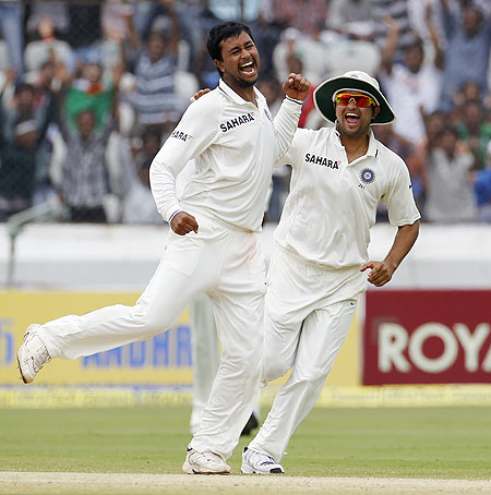 India's Pragyan Ojha (left) jumps as he celebrates with teammate Suresh Raina after taking   the wicket of New Zealand's Brendon McCullum
