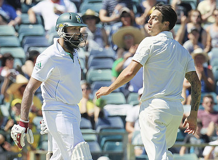Australia's Mitchell Johnson (right) looks back as South Africa's Hashim Amla (left) is dismissed at the WACA