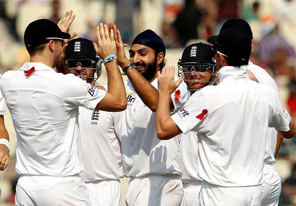 Monty Panesar celebrates with team-mates after taking the wicket of Cheteshwar Pujara