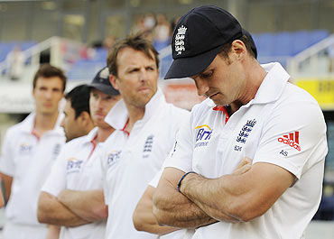 A distraught England captain Andrew Strauss (right) waits with teammates for the presentation ceremony after Pakistan won the third Test match in Dubai on Monday