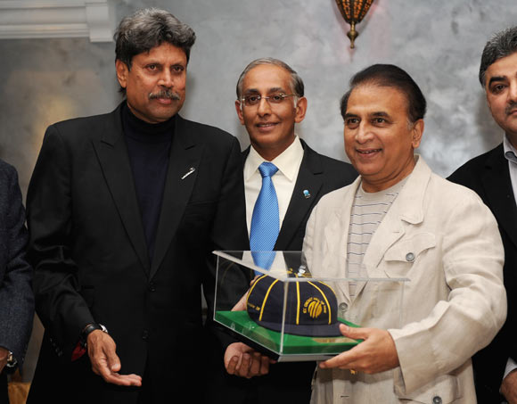 Former Indian cricketer Sunil Gavaskar (R) is presented with his ICC Hall of Fame cap by Kapil Dev (L) and ICC Chief Executive Haroon Lorgat